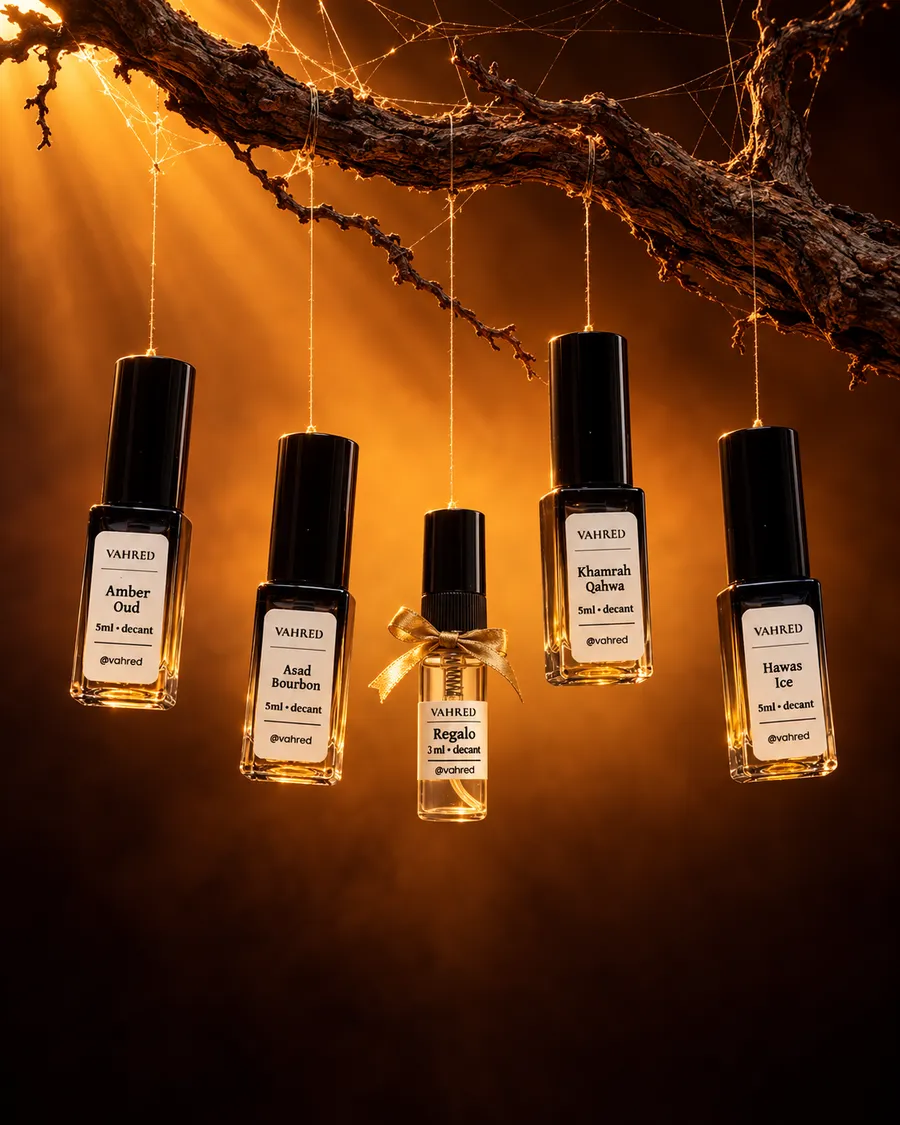 Cuatro decants VAHRED de 5 ml y un regalo de 3 ml con lazo dorado, suspendidos en una telaraña